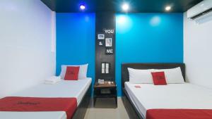 Postel nebo postele na pokoji v ubytování RedDoorz at Ranchotel Bayanan Alabang