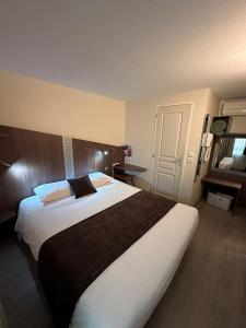 a bedroom with a large bed in a hotel room at Fasthotel Toulouse Blagnac A&eacute;roport in Blagnac