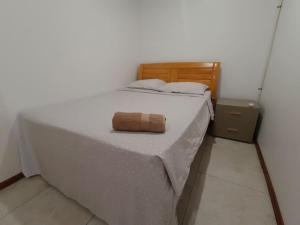 Una cama blanca con cabecero de madera y una toalla. en Exquisite 3-Bedroom Unit With Free Parking. en Nadi