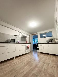 una cucina con armadietti bianchi e pavimenti in legno massello di Sunshine Rooms a Maroochydore Altre 4 foto