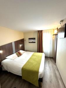 Cette chambre comprend un grand lit et une fenêtre. dans l'établissement Fasthotel Toulouse Blagnac Aéroport, à Blagnac