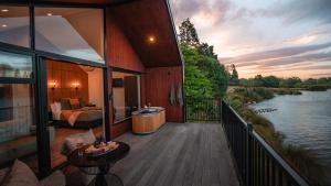 a room with a bed and a balcony with a river at HighTree Chalets 