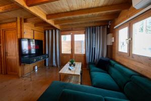 sala de estar con sofá verde y TV en Ktima to Alliotiko at Lofou Village, en Lofou