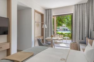 Cette chambre d'hôtel dispose d'un lit et offre une vue sur un patio. dans l'établissement Zulal Wellness Resort by Chiva-Som, à Ar Ruʼays