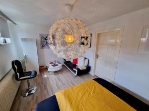 a room with a bed and a chandelier at Wohnen beim FotoGraf in Hannoversch Münden
