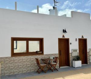 eine Terrasse mit 2 Stühlen, einem Tisch und einem Fenster in der Unterkunft La Graciosita Traditional Home in Caleta de Sebo