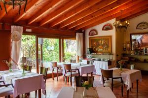 um restaurante com mesas e cadeiras brancas e janelas em S'Hort de Son Caulelles - Adults Only em Marratxí 