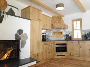 a kitchen with wooden cabinets and a fireplace at Great chalet in an idyllic location in Wagrain in Wagrain