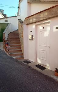 a white door with a staircase next to a building at Casa Evita in Sanxenxo