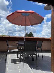 Le Chambon-Feugerolles的住宿－Hébergement Cosy avec terrasse Tropézienne，庭院内桌椅和遮阳伞