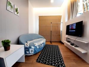 a small living room with a bed and a television at Symphony Tower Studio #9 with balcony in Cheras