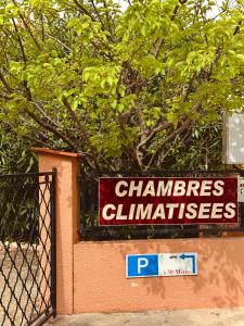 a sign on a wall next to a fence at Hôtel le Nid in Argelès-sur-Mer