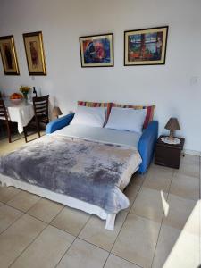 a bedroom with a blue bed and a table at Mariam Apartment in Larnaka