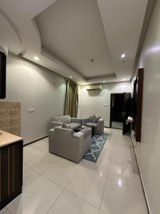 الجود للوحدات السكنية في الرياض: غرفة معيشة مع كنبتين وتلفزيون