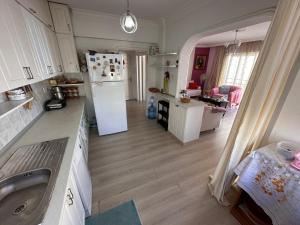 a kitchen with white cabinets and a white refrigerator at 2 bedroom apartment with sea view in Kyrenia centre in Kérynia
