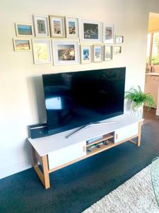 ein Wohnzimmer mit einem großen Flachbild-TV in der Unterkunft Beautiful 2 bedrooms Apartment in Kingsland, CBD in Auckland