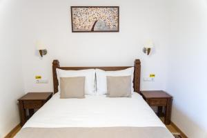 - une chambre avec un lit doté de draps et d'oreillers blancs dans l'établissement Pensiunea ROCA Maramureș, à Deseşti