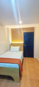 a bedroom with a bed and a blue door at Stone House Manila in Manila