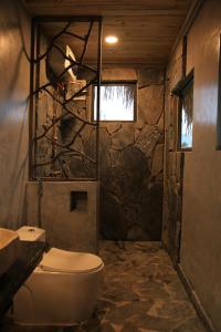 uma casa de banho com um WC e uma parede de pedra em Ha Giang Eco Stone House - Tours & Rental Motorbike em Bản Kin