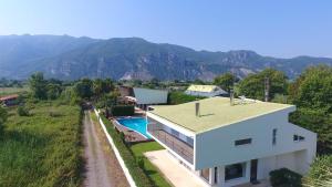 a house with a swimming pool and mountains in the background at Villa Temptation in Kamena Vourla