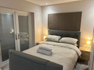 a bedroom with a large bed with two towels on it at The Tranquil Retreat in Llanfechell