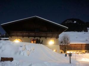 グロースアルルにあるPrivate Chalet in Grossarl with Sauna and Beautiful Viewの夜雪に覆われた建物