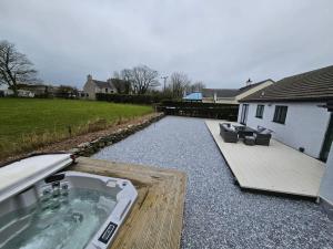 a backyard with a hot tub and a patio at The Tranquil Retreat in Llanfechell