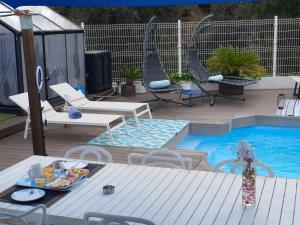 un patio con mesa y sillas junto a una piscina en Spa Ibiza Dosrius, en Canyamars