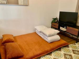 um quarto com uma cama com duas almofadas e uma televisão em L'Ambre - Appartement Raffiné em Perpignan