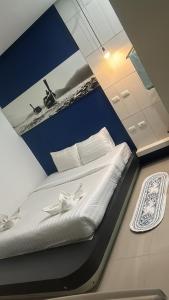 - un lit blanc dans une chambre ornée d'une peinture murale dans l'établissement Hotel The Journey Patong New, à Patong Beach