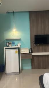 a room with a small refrigerator and a tv at Hotel The Journey Patong New in Patong Beach