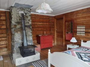 1 dormitorio con chimenea en una cabaña de madera en Swedish Paradise Garden & Lake Retreat 