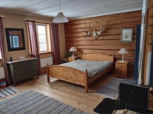 1 dormitorio con 1 cama y pared de madera en Swedish Paradise Garden & Lake Retreat 