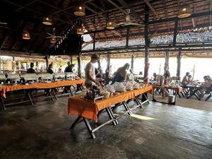 a group of people standing at tables in a restaurant at Phi Phi Relax Beach Resort in Phi Phi Islands