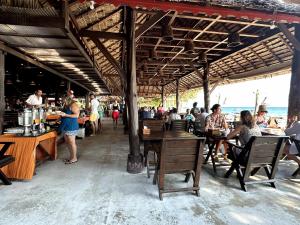 a group of people sitting at tables in a restaurant at Phi Phi Relax Beach Resort in Phi Phi Islands