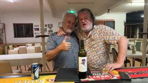 dos hombres parados en una mesa con una botella de vino en Lyndhurst hotel SA, 