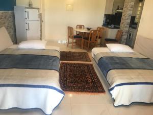 two beds in a room with a kitchen and a table at Latchi Holiday Flat in Polis Chrysochous +27 photos