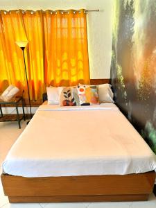 a bedroom with two beds with orange curtains at Casa Generosa in Baguio
