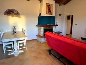 ein Wohnzimmer mit einem roten Sofa und einem Kamin in der Unterkunft Villetta nel bosco tra Firenze Arezzo e Siena in Terranuova Bracciolini