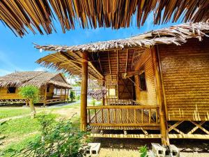 een huis met een rieten dak en een tuin bij Check in Lanta in Koh Lanta