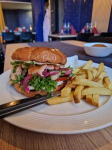 a sandwich and french fries on a white plate at WatchHouse in Hamina