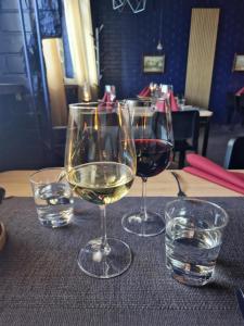 trzy kieliszki wina siedzące na stole z wodą w obiekcie WatchHouse w mieście Hamina