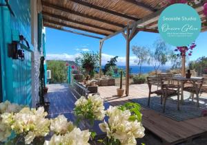 un patio con mesa y vistas al océano en Oneiro glico, en Agia Marina Aegina