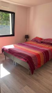1 cama grande en un dormitorio con ventana en Villa des églantines maison jacuzzi bord de mer en Saint-Jean-de-Monts
