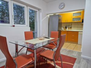 a kitchen with a glass table and orange chairs at Apartment F.R.I.E.N.D.S in Paraćin