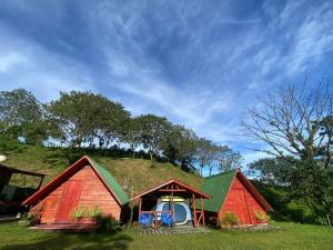 two houses with a grassy hill on top of them at Sunset Inn Arenal B&B in El Castillo de La Fortuna