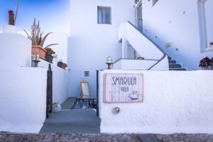 a stairway with a sign on the side of a building at Smarula Villa in Firostefani