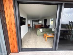 een uitzicht op een woonkamer door een glazen schuifdeur bij Totara Ridge in Rotorua