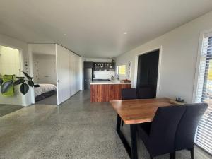 una cucina e una sala da pranzo con tavolo e sedie di Totara Ridge a Rotorua