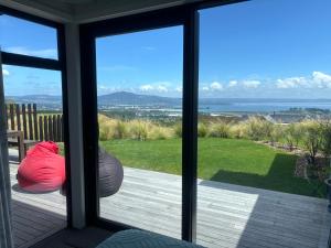 a room with a sliding glass door looking out at the ocean at Totara Ridge in Rotorua